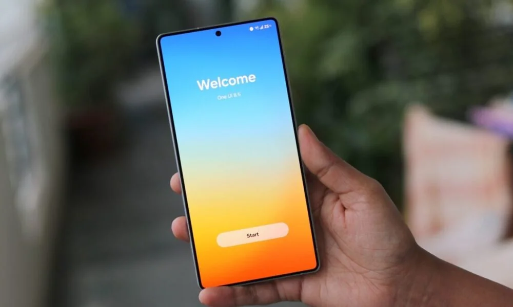 Samsung Smartphone mit Willkommensbildschirm in der Hand vor unscharfem grünen Hintergrund