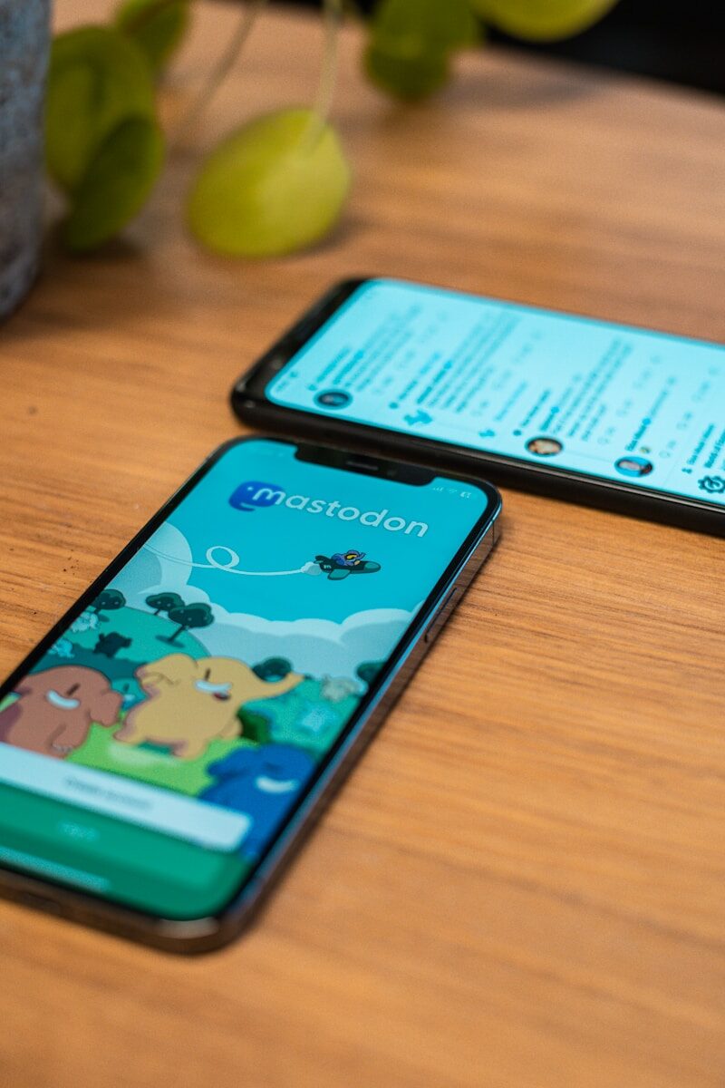 Mastodon-App und Textseite auf Smartphones a couple of cell phones on a table